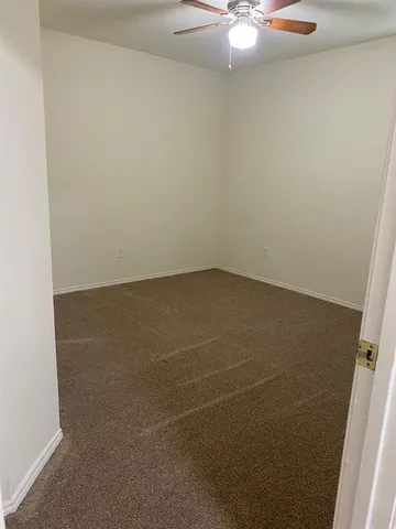 an empty room with a chandelier fan