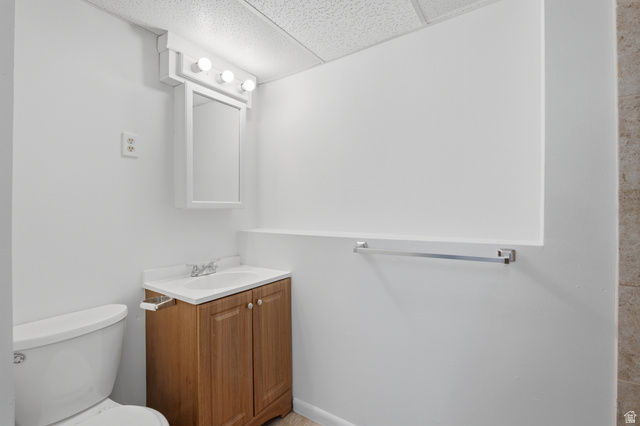 7910 Woolley Way Magna, UT 84044 - Photo 17 of 26 Bathroom featuring a wood-finish vanity with an integrated sink, a mirrored medicine cabinet, and a four-bulb vanity light fixture