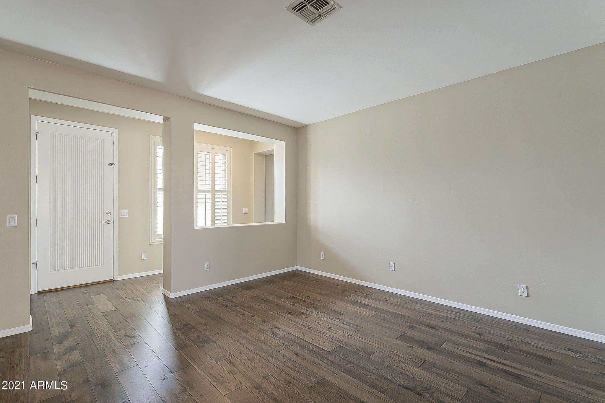 15346 West Boca Raton Road Surprise, AZ 85379 - Photo 10 of 45 a view of an empty room with wooden floor and a window