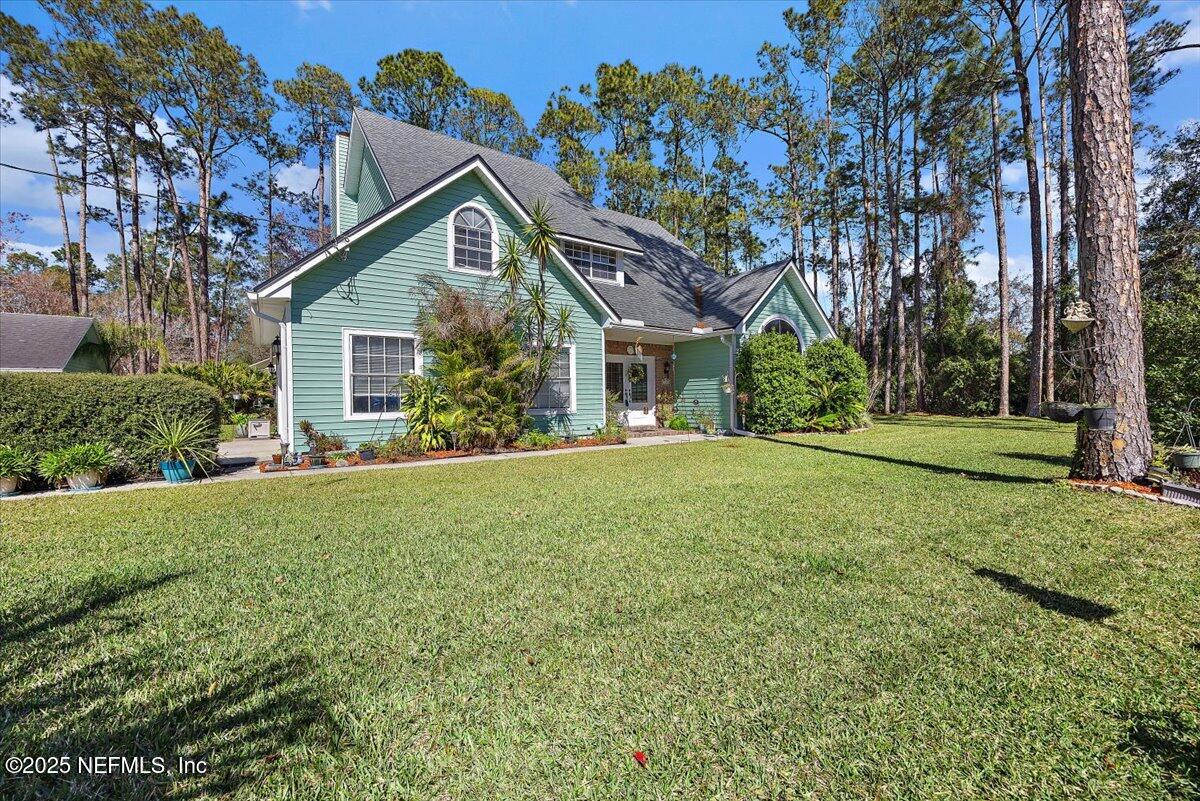 415 Bald Eagle Road Fleming Island, FL 32003 - Photo 25 of 27 a house with huge green field in front of it