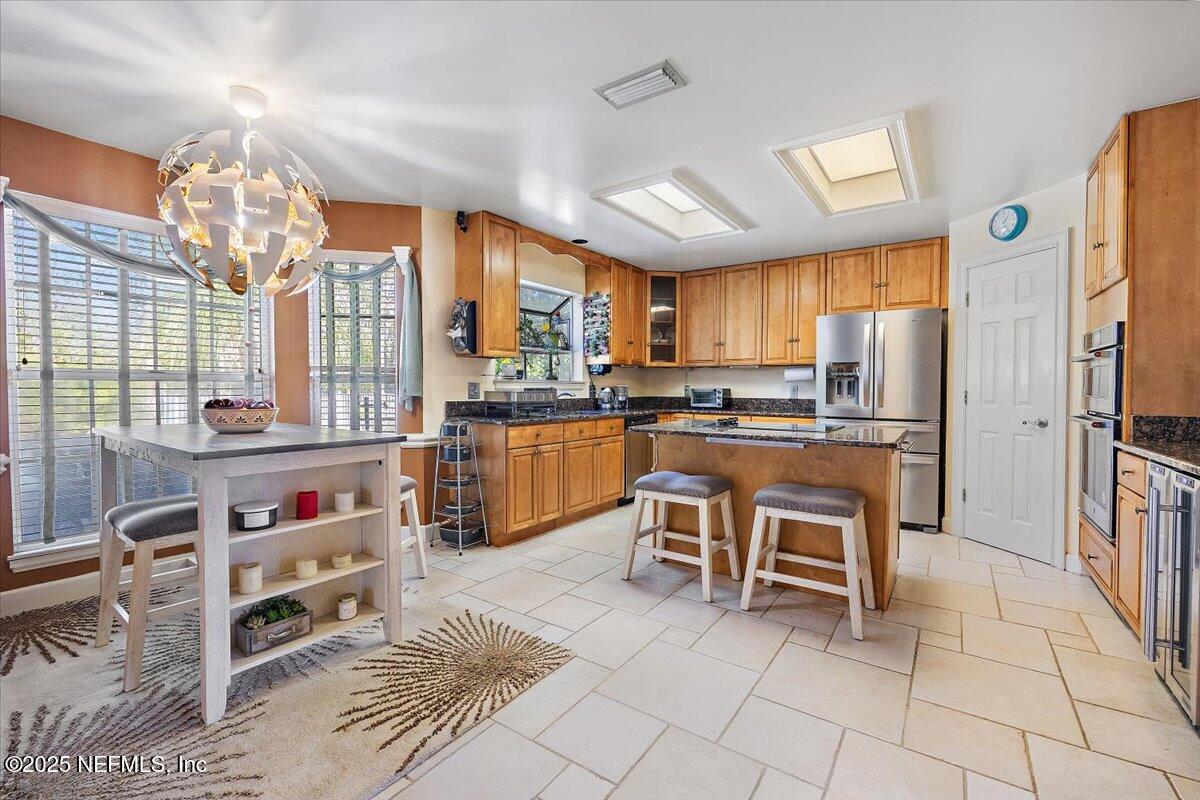 415 Bald Eagle Road Fleming Island, FL 32003 - Photo 8 of 27 a kitchen with granite countertop a stove a sink and a refrigerator
