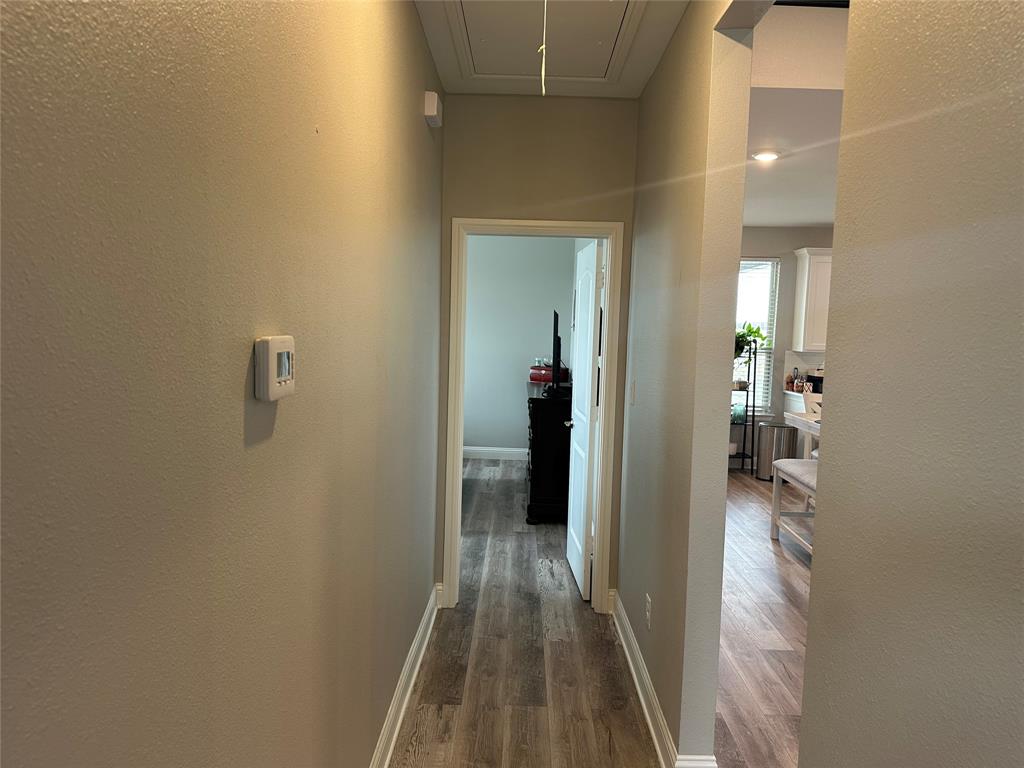4760 County Road 4603 Commerce, TX 75428 - Photo 16 of 36 a view of a hallway with wooden floor and a bathroom