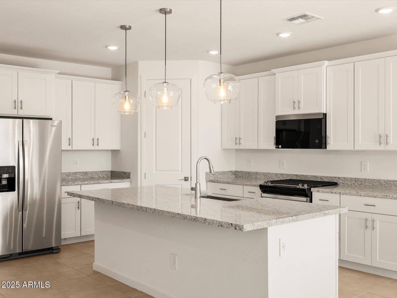 2426 Grenache Road San Tan Valley, AZ 85143 - Photo 5 of 73 a kitchen with stainless steel appliances granite countertop a sink a stove a refrigerator a center island and cabinets