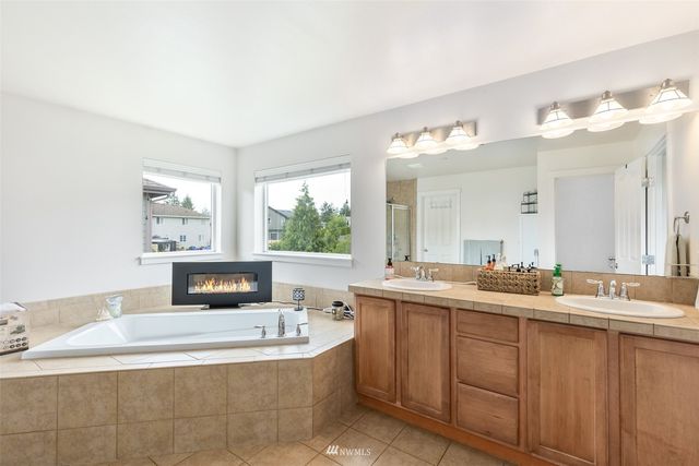 a bathroom with a tub sink and mirror