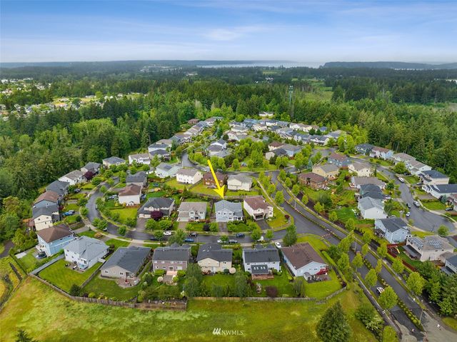 an aerial view of residential houses with outdoor space and trees