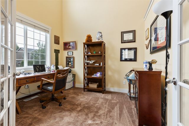 a view of a workspace with furniture and a window