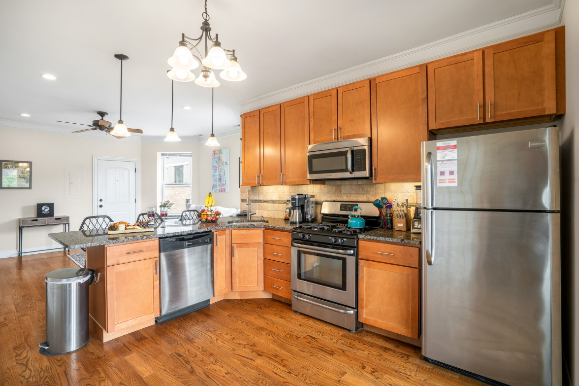 2117 West Irving Park Road, Unit 2R Chicago, IL 60618 - Photo 9 of 16 a kitchen with stainless steel appliances granite countertop a refrigerator a stove a sink dishwasher a refrigerator with wooden floor