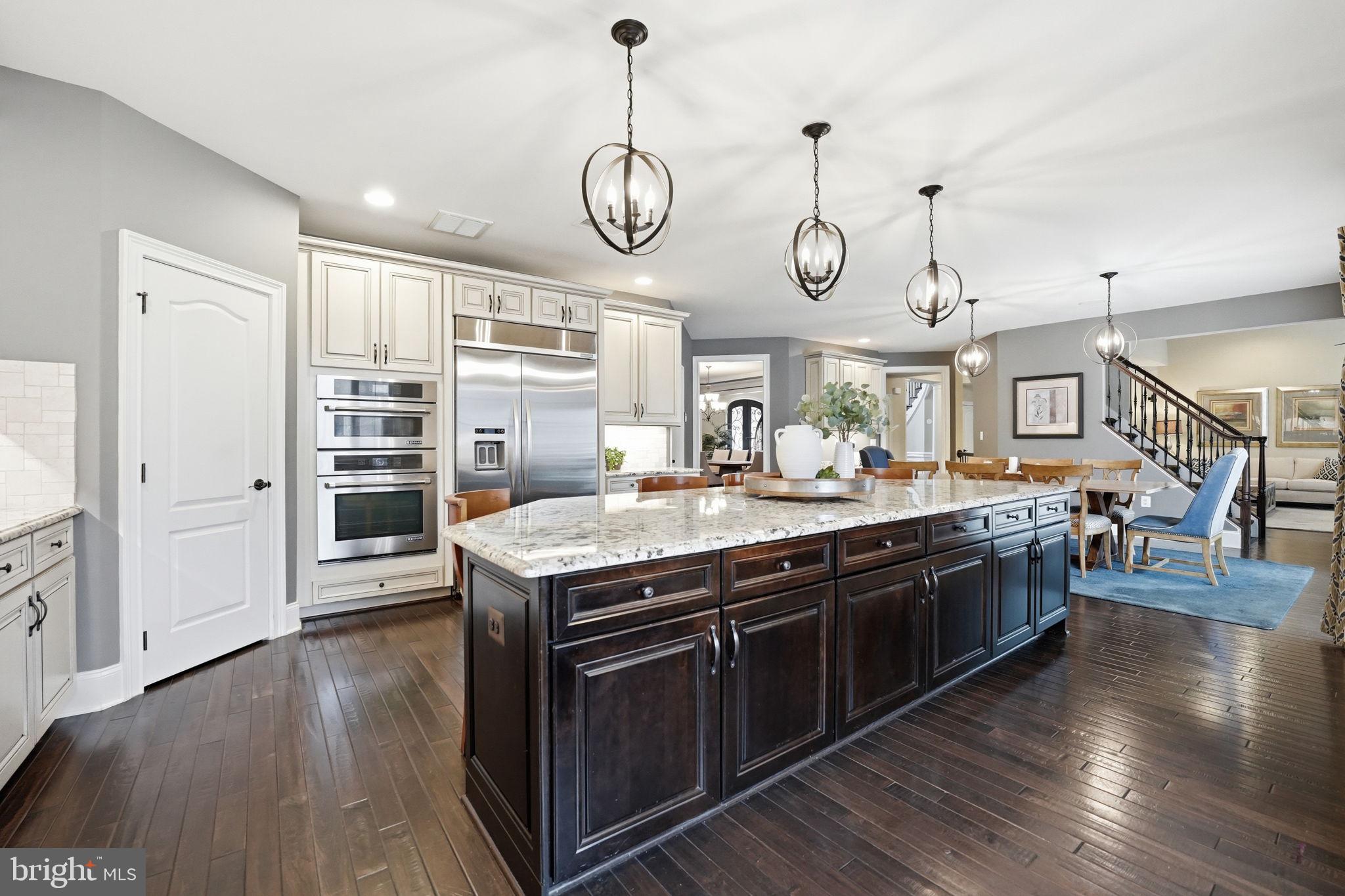 17972 Running Colt Place Leesburg, VA 20175 - Photo 20 of 99 a large kitchen with stainless steel appliances granite countertop a stove and wooden floor