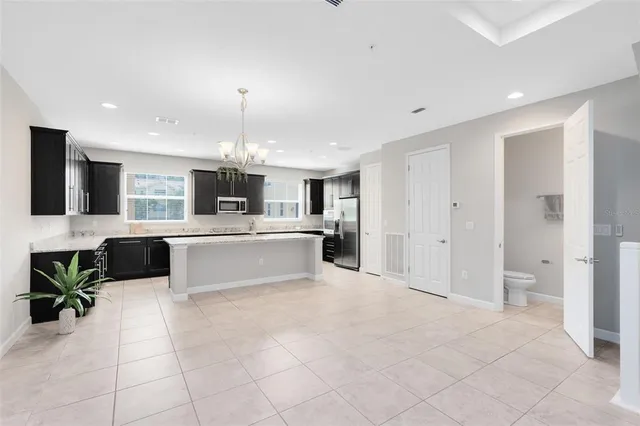 a large kitchen with stainless steel appliances a stove sink and cabinets
