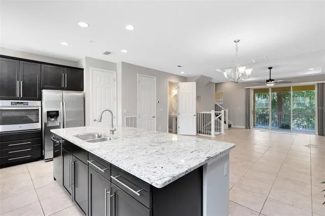 a kitchen with kitchen island granite countertop a sink a counter top stainless steel appliances and cabinets