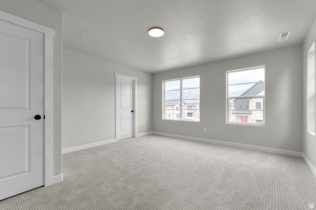 1567 North 3250 West Provo, UT 84601 - Photo 21 of 22 Spacious interior room featuring light gray carpeting, two white two-panel doors with matte black hardware, and multiple windows with white trim
