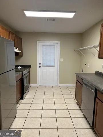 a kitchen with a stove a refrigerator and cabinets