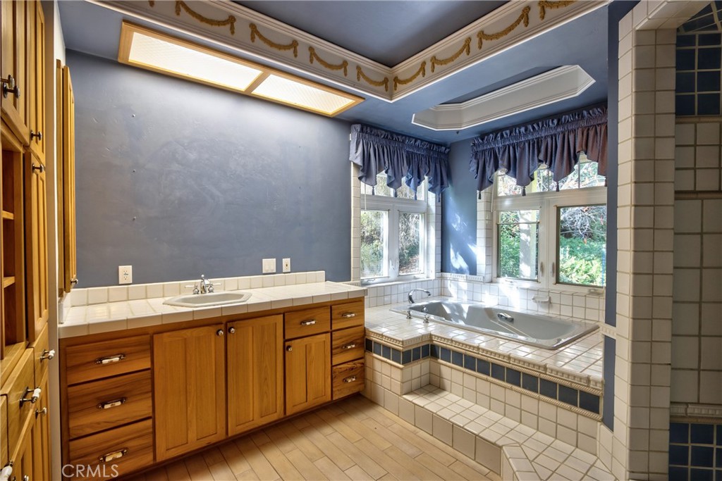 46341 El Prado Road Temecula, CA 92590 - Photo 21 of 52 a spacious bathroom with a granite countertop sink mirror and a bathtub