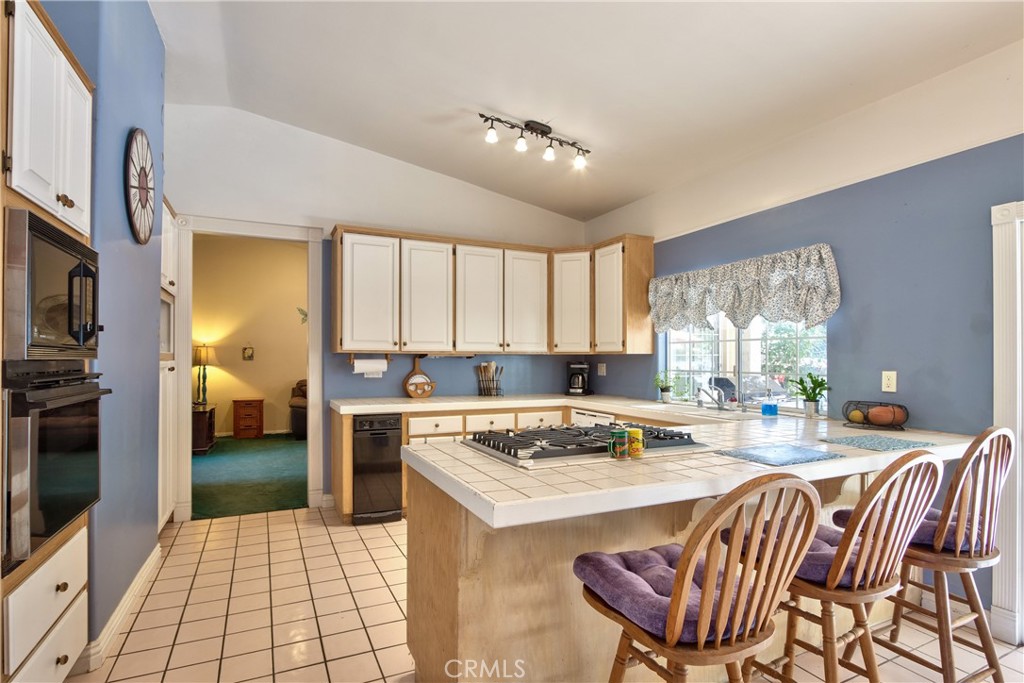 46341 El Prado Road Temecula, CA 92590 - Photo 32 of 52 a kitchen with a stove a sink dishwasher and a refrigerator with wooden floor