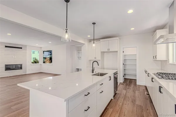 a kitchen with a sink stove and wooden floor