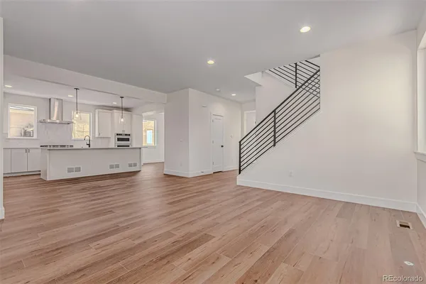 a view of a kitchen with wooden floor and a window