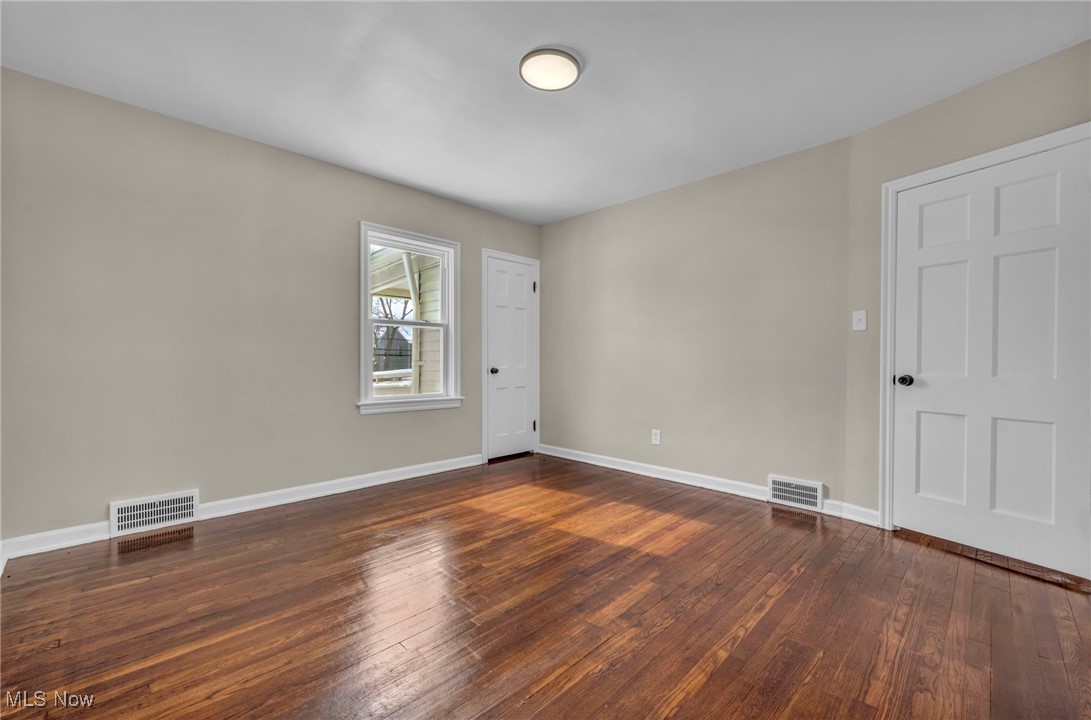 13614 Cedar Road Cleveland, OH 44118 - Photo 27 of 46 Empty room featuring dark wood-style flooring, visible vents, and baseboards