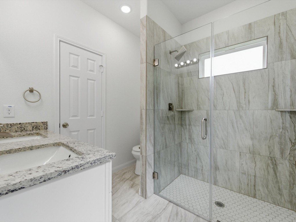 2803 Topiary Lane Houston, TX 77014 - Photo 18 of 30 The primary en-suite is thoughtfully finished with dual sinks, a sleek glass-enclosed shower, and a spacious walk-in closet designed for everyday comfort.