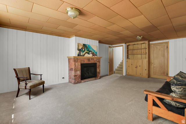 6 Terrace Place Logan, UT 84321 - Photo 23 of 26 Spacious basement recreation room featuring a brick fireplace with hearth, wood-finish ceiling with recessed lighting, neutral carpet flooring, and multiple wooden storage closets