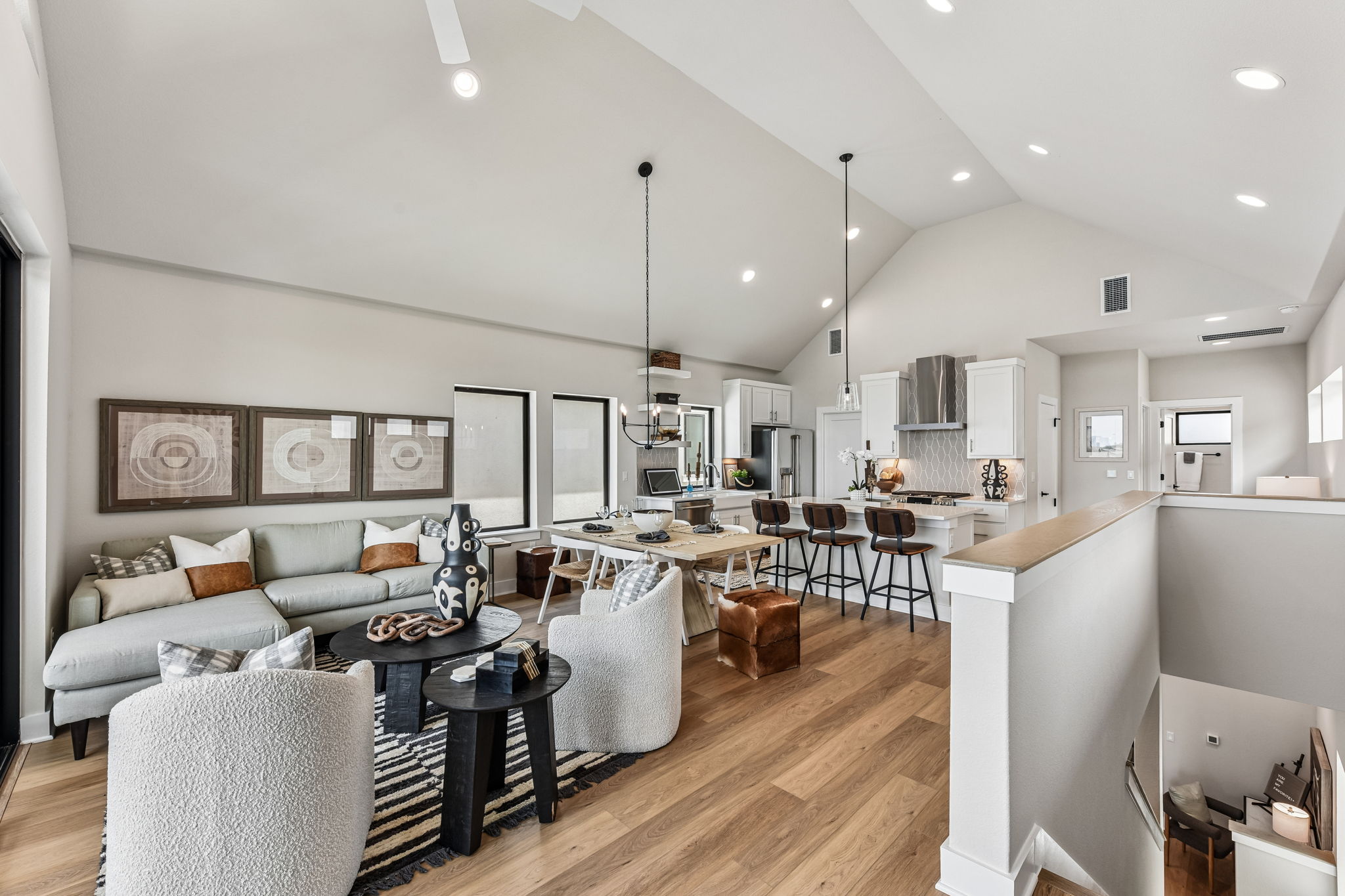 9101 Cattle Baron Path Austin, TX 78747 - Photo 13 of 40 An open concept living area boasts vaulted ceilings and rich hardwood flooring, seamlessly connecting to a modern kitchen.