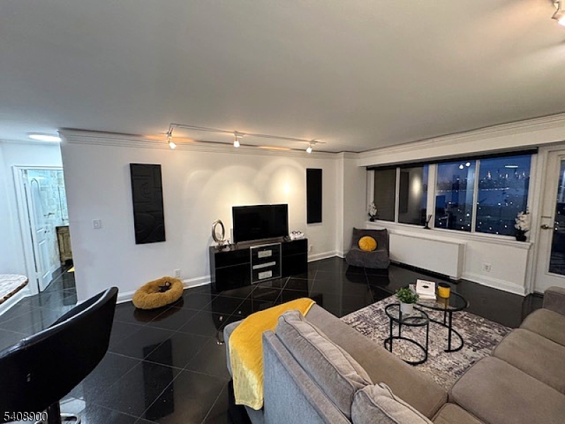 1203 River Road, Unit 19K Edgewater, NJ 07020 - Photo 3 of 19 a living room with furniture and a flat screen tv