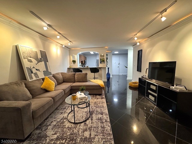 1203 River Road, Unit 19K Edgewater, NJ 07020 - Photo 4 of 19 a living room with furniture and a flat screen tv