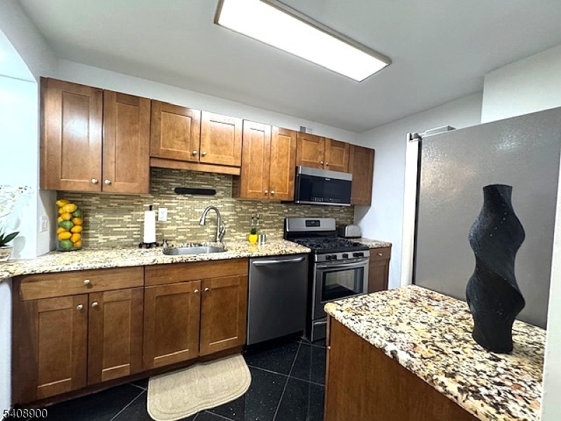 1203 River Road, Unit 19K Edgewater, NJ 07020 - Photo 6 of 19 a kitchen with a sink stove and refrigerator