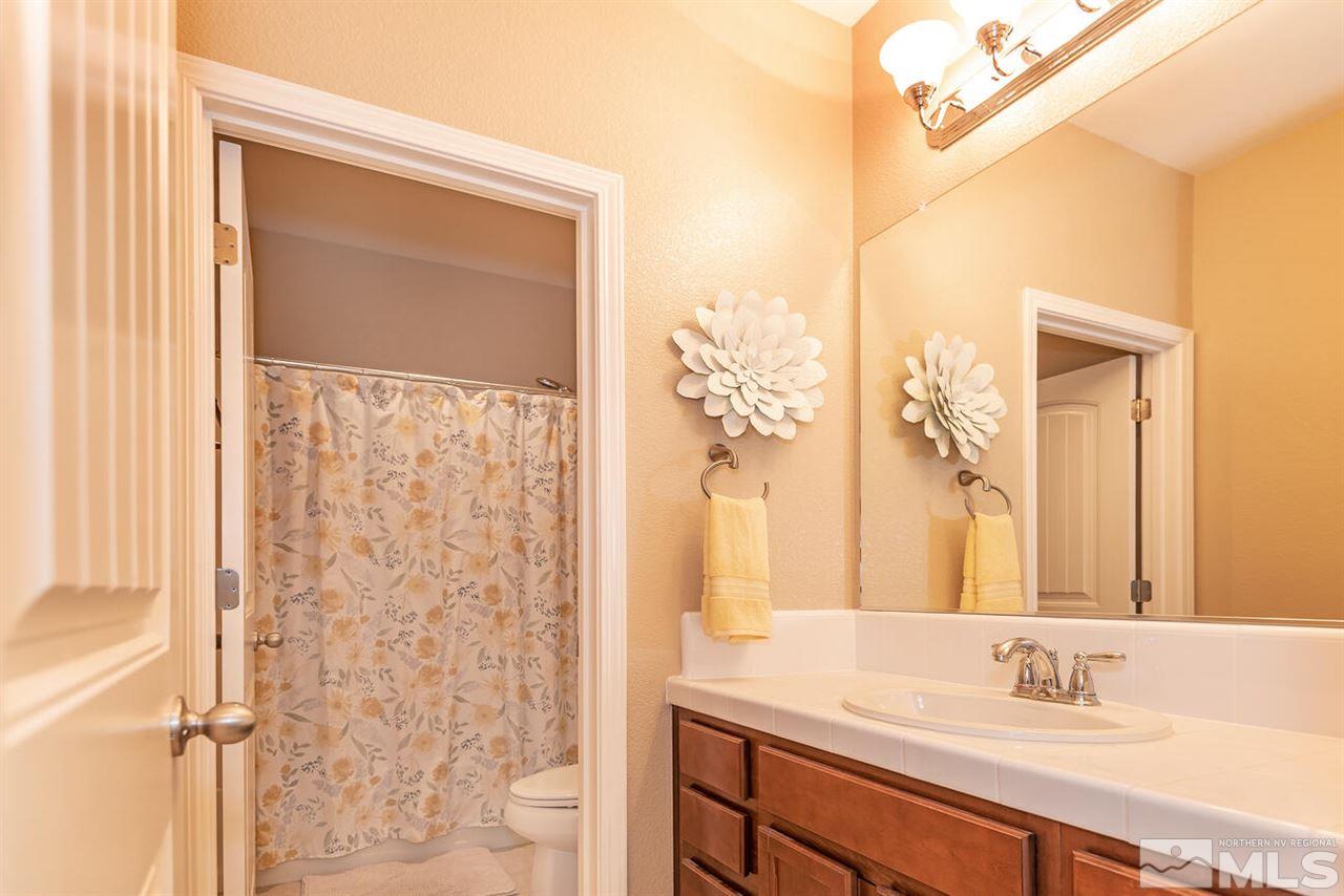 2065 Bears Ranch Drive Reno, NV 89521 - Photo 14 of 20 a bathroom with a granite countertop sink a mirror and a shower