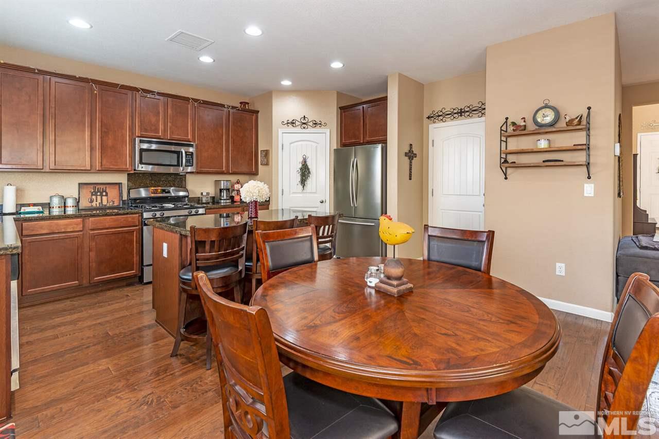 2065 Bears Ranch Drive Reno, NV 89521 - Photo 6 of 20 a kitchen with stainless steel appliances granite countertop a stove a refrigerator a sink a dining table and chairs