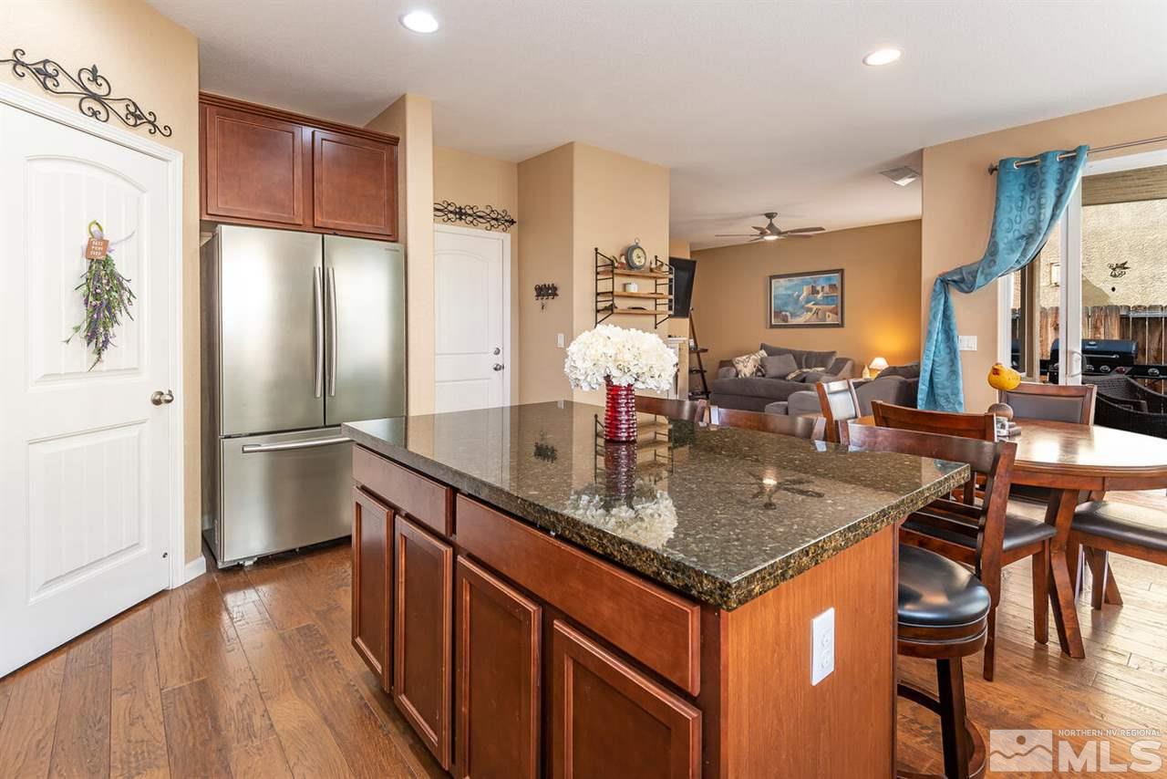 2065 Bears Ranch Drive Reno, NV 89521 - Photo 7 of 20 a kitchen with stainless steel appliances granite countertop a refrigerator a stove and a wooden floors