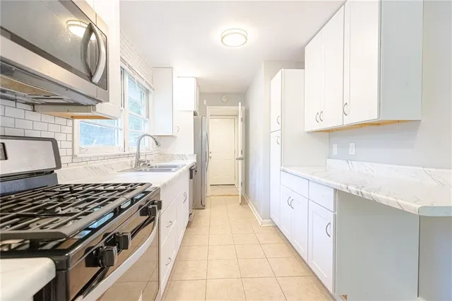 a kitchen with stainless steel appliances granite countertop a stove and a sink