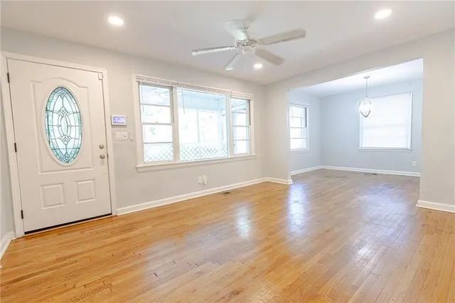 a view of an empty room with a window and wooden floor