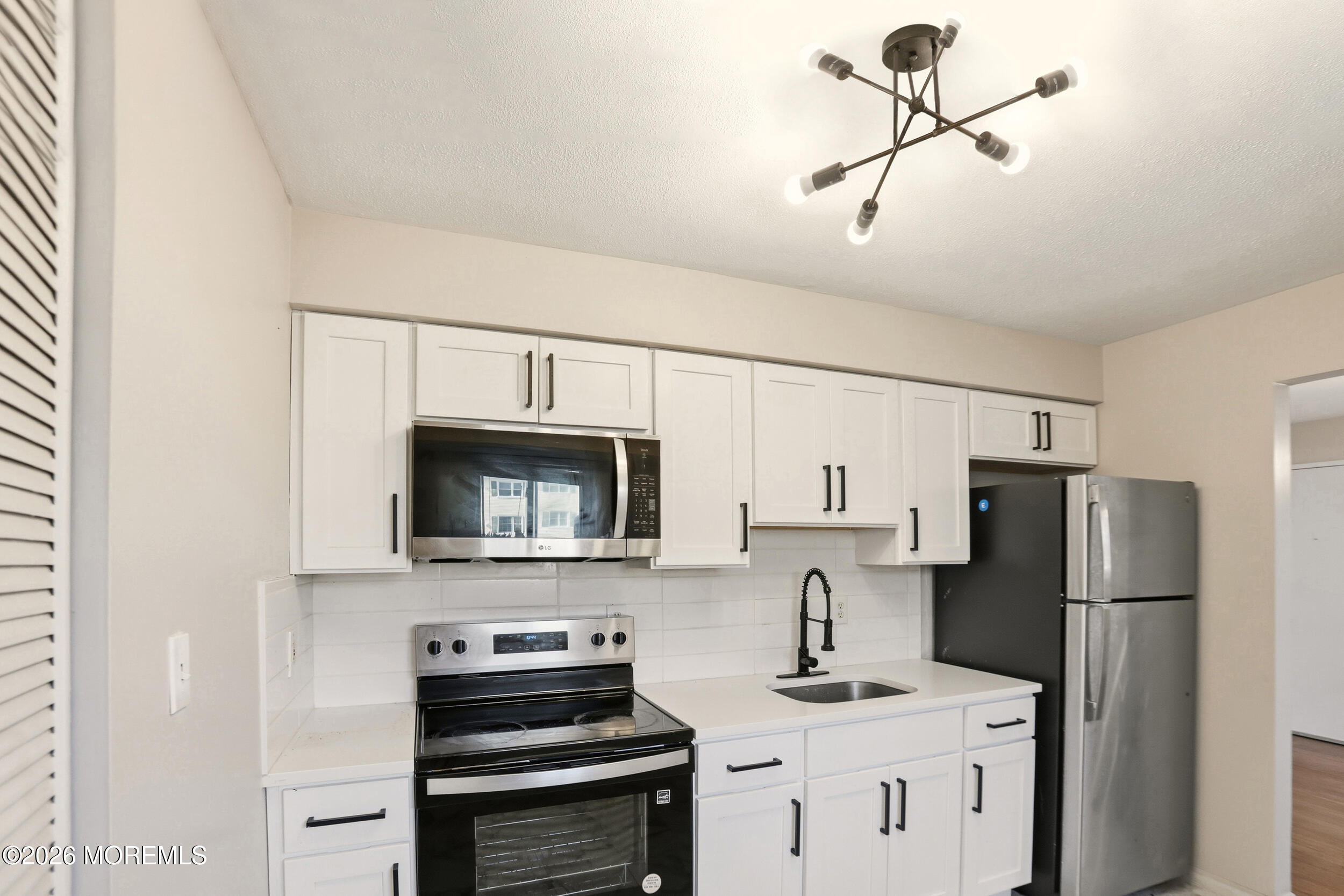 194 Sawmill Road, Unit 480 Brick, NJ 08724 - Photo 17 of 20 a kitchen with a refrigerator and a stove top oven