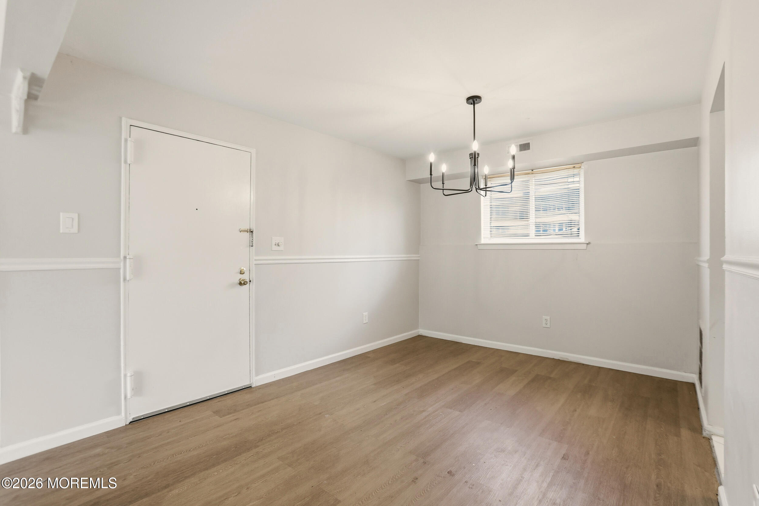 194 Sawmill Road, Unit 480 Brick, NJ 08724 - Photo 6 of 20 an empty room with wooden floor chandelier and windows