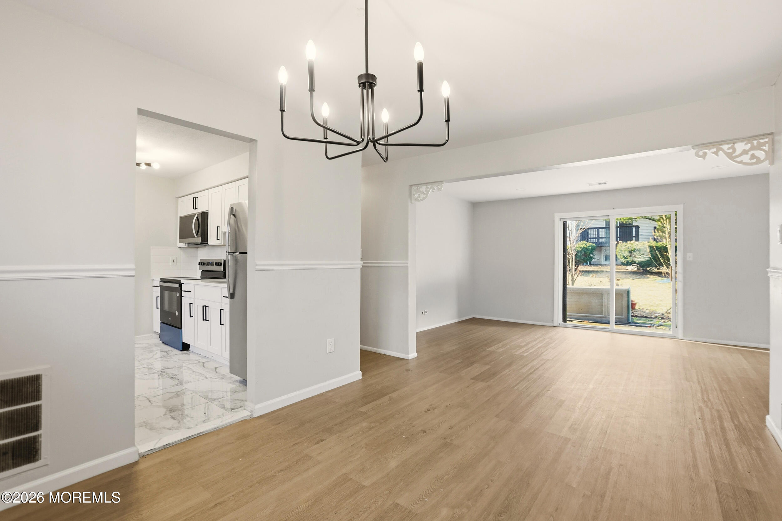 194 Sawmill Road, Unit 480 Brick, NJ 08724 - Photo 8 of 20 a view of a kitchen with wooden floor and a chandelier