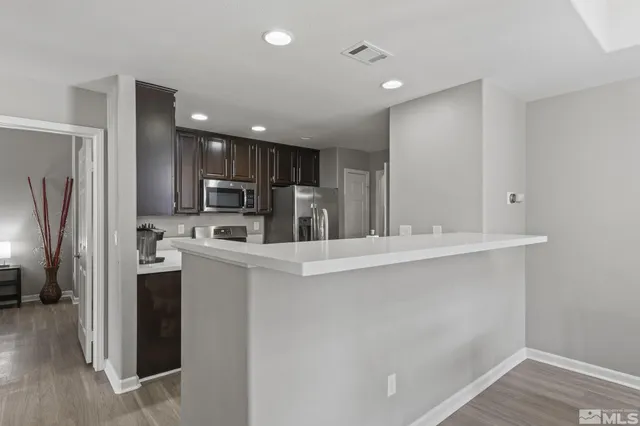 a kitchen with kitchen island a sink stainless steel appliances and cabinets