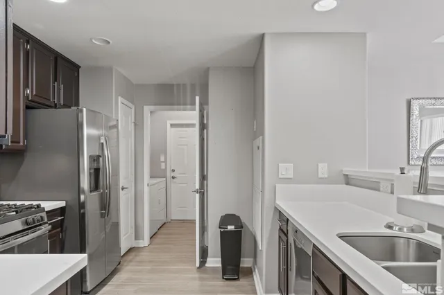 a view of a kitchen with a sink refrigerator and wooden floor