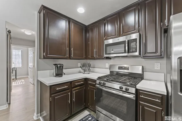 a kitchen with granite countertop stainless steel appliances and cabinets