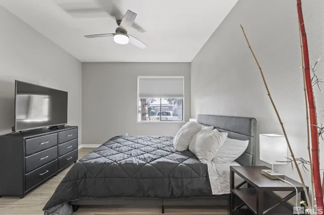 a bedroom with a bed and a flat tv screen on the dresser