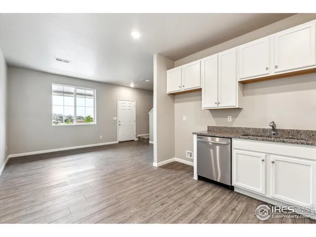a view of kitchen with granite countertop stainless steel appliances refrigerator sink and cabinets