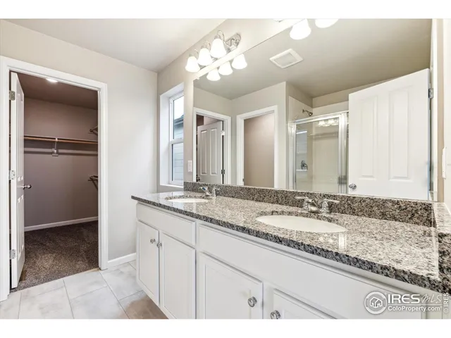 a bathroom with a granite countertop sink a mirror and a shower