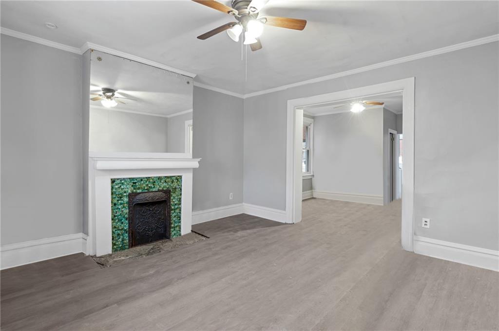 1210 Maple Avenue, Unit 1 Turtle Creek, PA 15145 - Photo 2 of 5 wooden floor fireplace and windows in an empty room