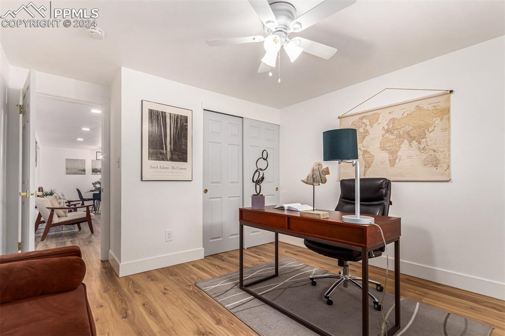 737 Utica Street Denver, CO 80204 - Photo 12 of 41 a workspace with wooden floor and a chandelier fan
