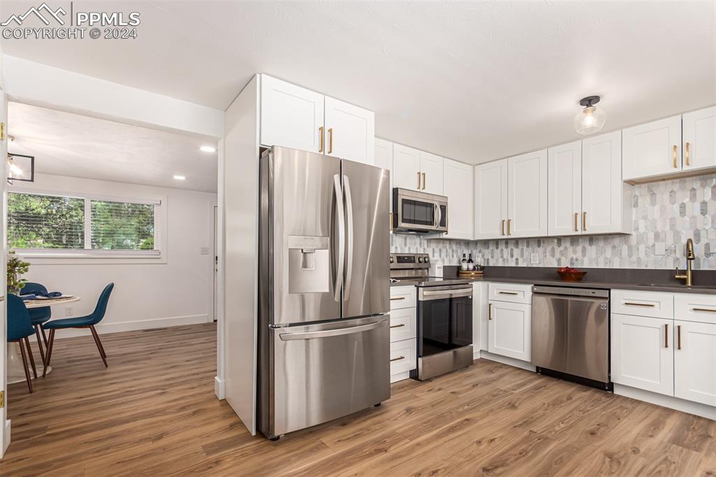 737 Utica Street Denver, CO 80204 - Photo 16 of 41 a kitchen with wooden floors stainless steel appliances and window