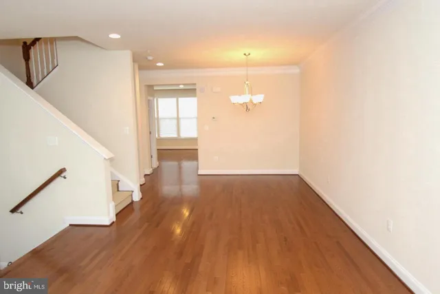 a kitchen with stainless steel appliances granite countertop a stove top oven a sink dishwasher and a refrigerator with wooden floor