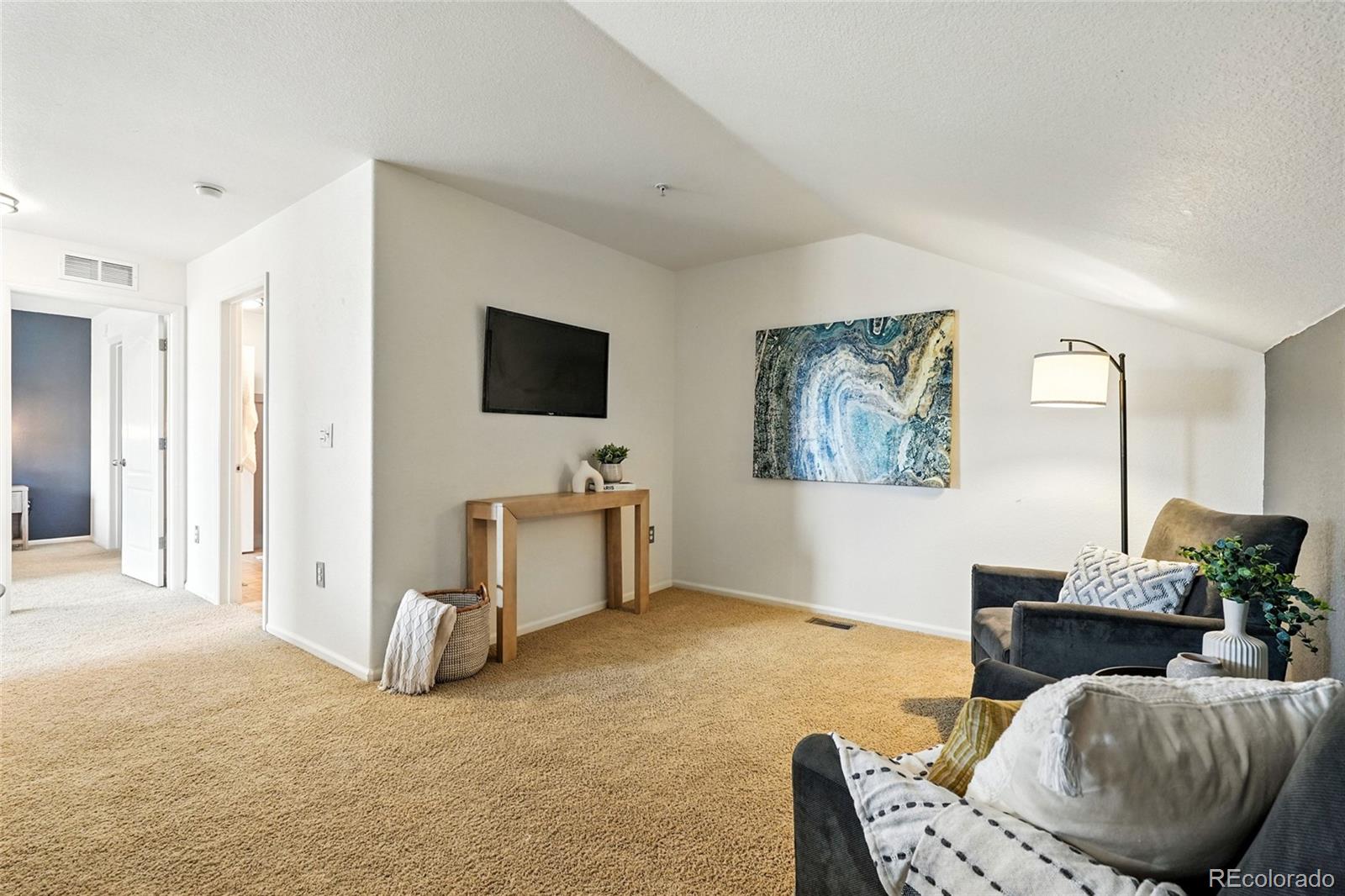 7080 Simms Street, Unit 204 Arvada, CO 80004 - Photo 32 of 49 a living room with furniture and a flat screen tv