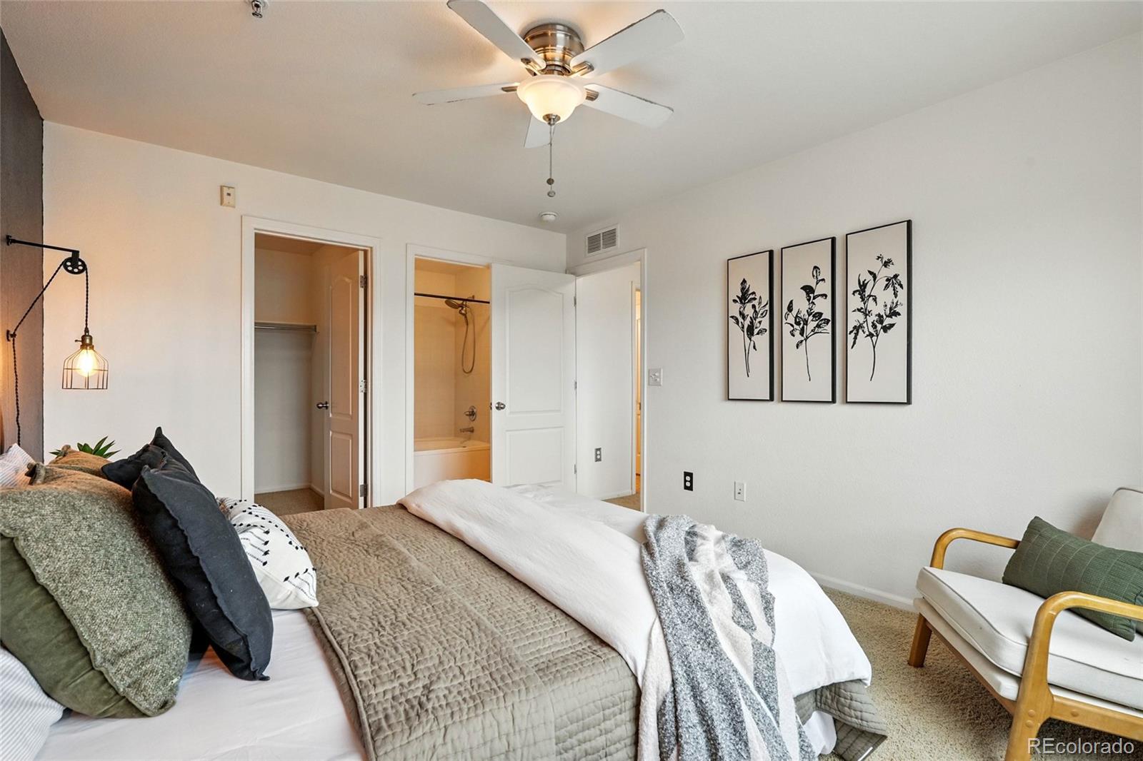 7080 Simms Street, Unit 204 Arvada, CO 80004 - Photo 35 of 49 a bedroom with a bed and a chandelier