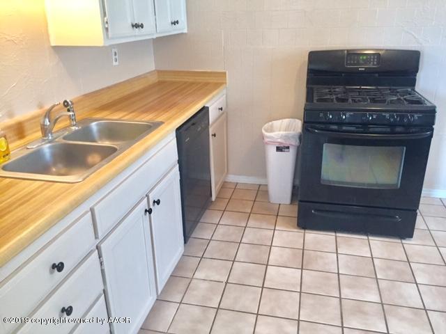 4219 South Ong Street Amarillo, TX 79110 - Photo 13 of 24 a kitchen with a stove top oven and cabinets