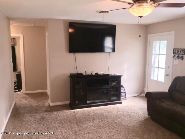 4219 South Ong Street Amarillo, TX 79110 - Photo 10 of 24 a living room with a flat screen tv and a fireplace