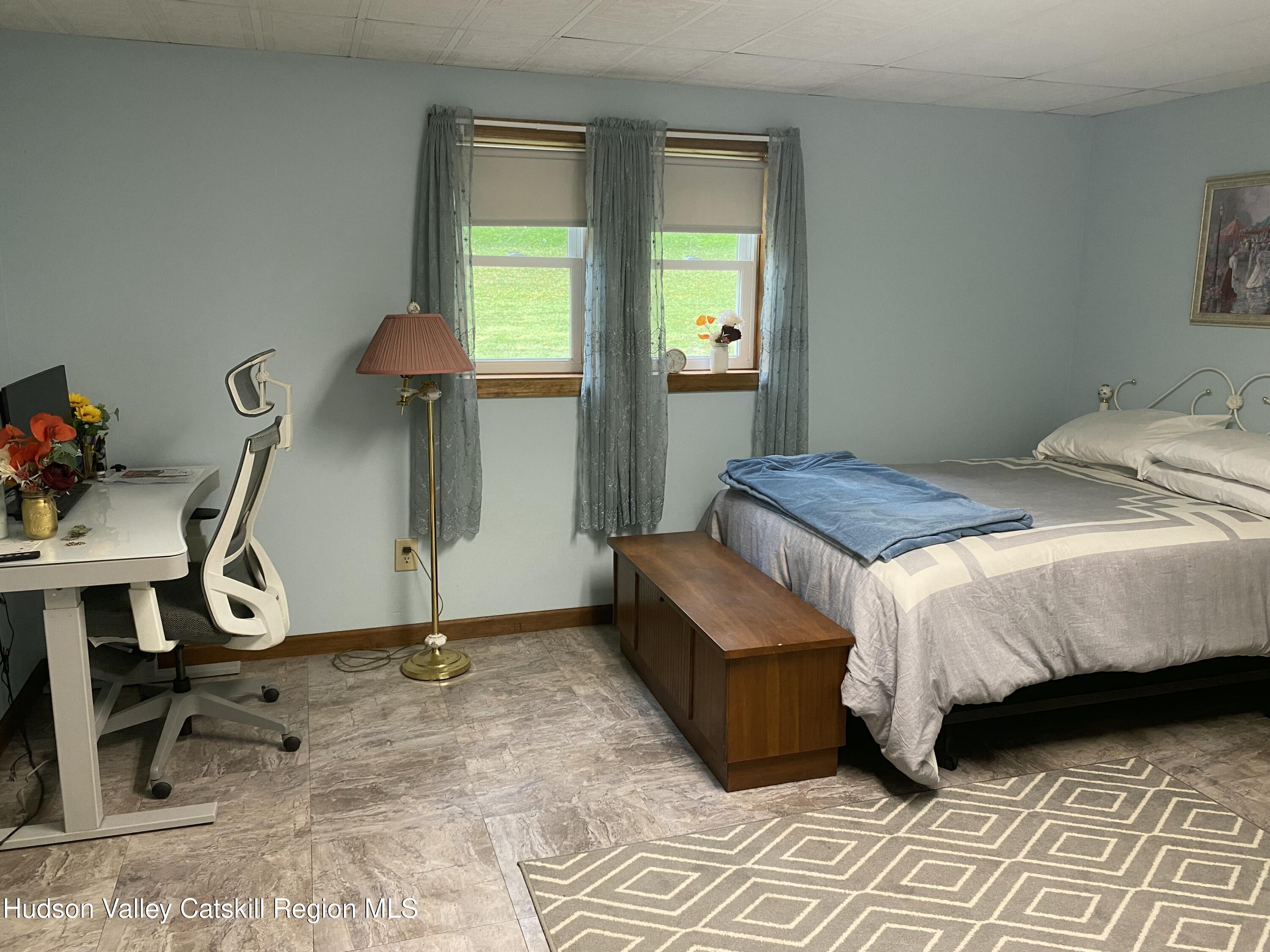 22 Beacham Road Rhinebeck, NY 12572 - Photo 28 of 38 a bedroom with a bed a lamp and windows